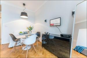 a dining room with a white table and chairs at P&O Apartments Poznańska in Warsaw