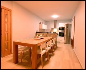 a kitchen with a wooden table and chairs at Iturraldea I y II in Etxalar