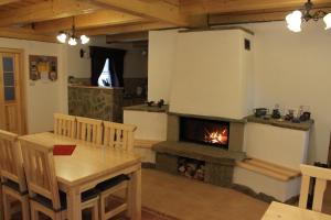 a living room with a fireplace and a table and a table and chairs at Drevenice Zuberec in Zuberec