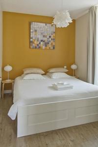 ル・クロワジックにあるLes Salorgesの黄色い壁の客室で、白い大型ベッド1台が備わります。