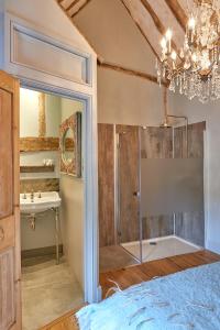 a bathroom with a shower and a sink and a chandelier at The Broad Leys in Aylesbury