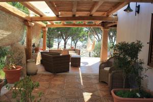 a wooden pergola with couches and chairs on a patio at Casa Degli Ulivi in Cala Liberotto
