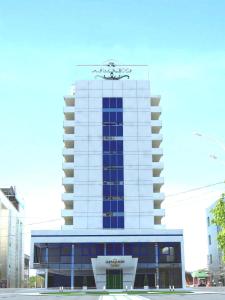 ein hohes weißes Gebäude mit einem Schild darüber in der Unterkunft Armavir Hotel in Armawir