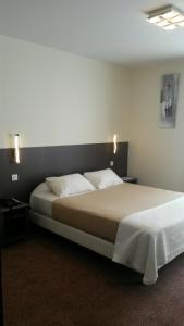 1 dormitorio con 1 cama grande en una habitación en Hôtel de La Cloche, en Dole