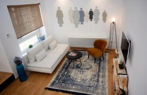 札格雷布的住宿－Studio Apartman Olaf，客厅配有白色沙发和地毯。