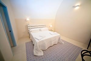 um quarto com uma cama com uma colcha branca em B&B Palazzo del Capitolo - By I Bastioni San Domenico em Gallipoli