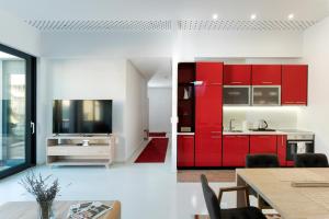 a kitchen with red cabinets and a dining room at BA Apartments in Sarajevo