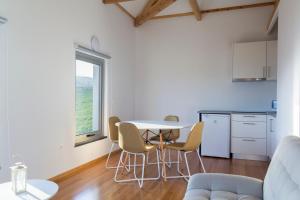 a kitchen with a table and chairs in a room at Lofts Azul Pastel in Horta