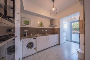 a kitchen with a washing machine and a sink at Sintra Wine Apartment in Sintra