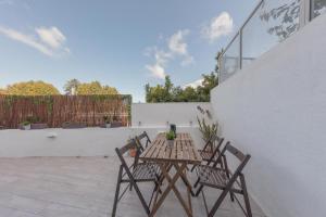 einen Holztisch und zwei Stühle auf einer Terrasse in der Unterkunft Sintra Wine Apartment in Sintra