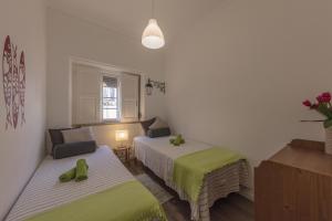 Zimmer mit 2 Betten und grüner Bettwäsche in der Unterkunft Sintra Wine Apartment in Sintra