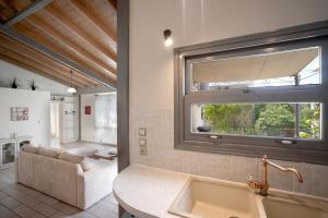 uma casa de banho com um lavatório, uma janela e um sofá em Valashouse em Atenas
