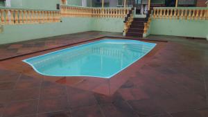 a swimming pool in the middle of a tiled floor at Pousada Victor in Ribeirão Claro +29 photos