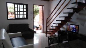 a living room with a couch and a staircase at Apartamento em Ubatuba in Ubatuba