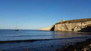 a boat in the water next to a rocky beach at Casa degli Oleandri in Santa Caterina