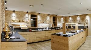 a large kitchen with wooden cabinets and a counter at Sporthotel Krone in Schoppernau
