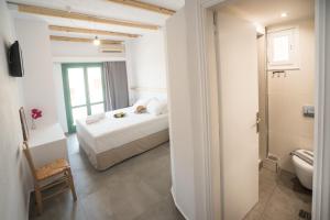 a white bedroom with a bed and a toilet at Ifestia Hotel in Kamari +59 photos