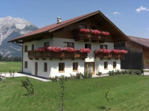 une maison avec des fleurs sur les balcons sur une colline dans l'établissement Ferienwohnung Prader, à Innsbruck