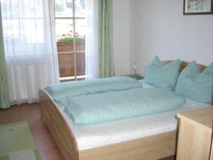 Bett in einem Zimmer mit Fenster in der Unterkunft Ferienwohnung Prader in Innsbruck