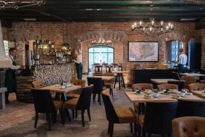 a restaurant with wooden tables and chairs and a brick wall at Mustion Linna / Svartå Manor in Svartå