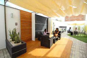 a group of people sitting in chairs on a patio at Takora Inn in Tacna