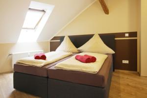 ワイマールにあるアパートメンツ ルーストラスのベッドルーム1室(赤い枕のベッド2台付)