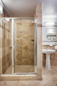uma casa de banho com um chuveiro e um lavatório. em Porto Vista Hotel In Little Italy em San Diego