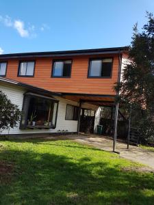 ein großes orangenes Haus mit einem Hof davor in der Unterkunft Mar-al Apartments in Valdivia