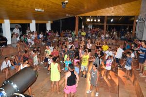 a group of children dancing in a crowd of people at Villaggio Camping La Scogliera in Ricadi