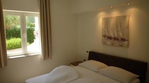 a bedroom with a bed with two pillows and a window at Villa Simfonija in Malinska