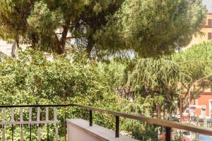 un balcone con ringhiera, alberi e edifici di B&B JONIO Roma a Roma
