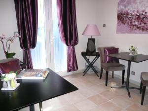 a living room with purple curtains and a table and chairs at Les 7 Roses d'Aix in Aix-en-Provence