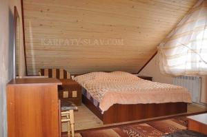 a bedroom with a bed and a wooden ceiling at Zacharovany Karpaty in Slavske