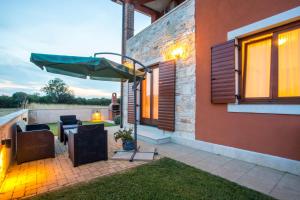 une terrasse avec un parasol, une table et des chaises dans l'établissement Apartman Irena, à Pula