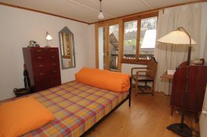 a bedroom with a bed and a desk and a chair at BnB Hasatrog Jenaz in Jenaz