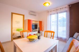 - une cuisine avec une table et un bol de fruits dans l'établissement Apartman Irena, à Pula