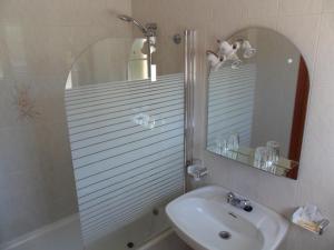 een badkamer met een wastafel en een douche met een spiegel bij Hotel Vimar in Sanxenxo