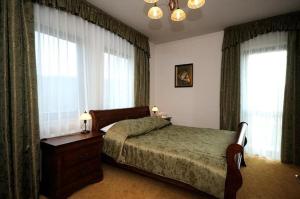 a bedroom with a bed and a dresser and windows at Hotel Salamandra in Hoczew
