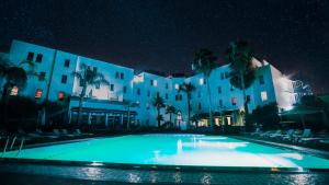 - un grand bâtiment avec une piscine la nuit dans l'établissement Ibis Fes, à Fès