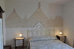 a bedroom with a white bed with two night stands at Masseria Pentima Vetrana Resort in Alberobello
