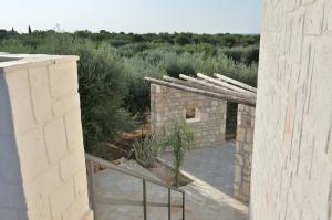 een extern uitzicht op een stenen gebouw met een trap bij Masseria Pentima Vetrana Resort in Alberobello