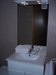 a bathroom with a white sink and a mirror at Hotel Edelweiss in Magland
