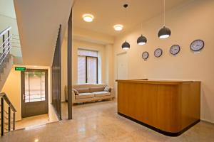 a lobby with a reception desk and clocks on the wall at Hotel Genio in Tbilisi City