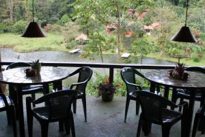 a patio with two tables and chairs and a window at Lucky Bug Bed And Breakfast in Nuevo Arenal