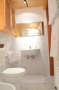 a bathroom with a white toilet and a sink at La Solatìa in Porto Ceresio