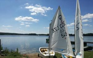 a small sail boat sitting on the shore of a lake at Yacht Club Bezdrev in Hluboká nad Vltavou