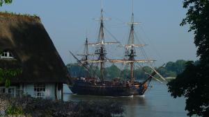 a large ship in the water near a house at La Bonne Auberge in Vieux-Port