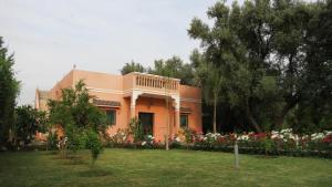 an orange house with flowers in a yard at Moorish House in Aghmat