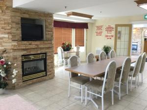 a dining room with a table and a fireplace at Western Budget Motel #2 Grande Prairie in Grande Prairie