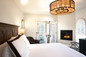 a bedroom with a white bed and a fireplace at North Block Hotel in Yountville